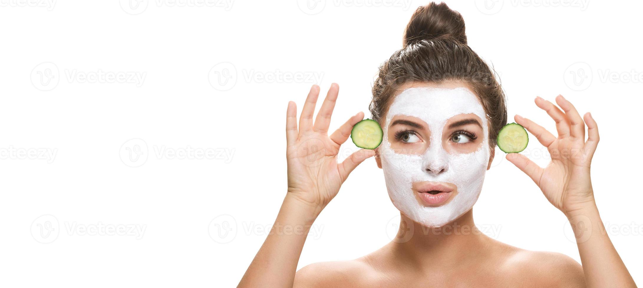 donna con facciale maschera e cetriolo fette nel sua mani foto