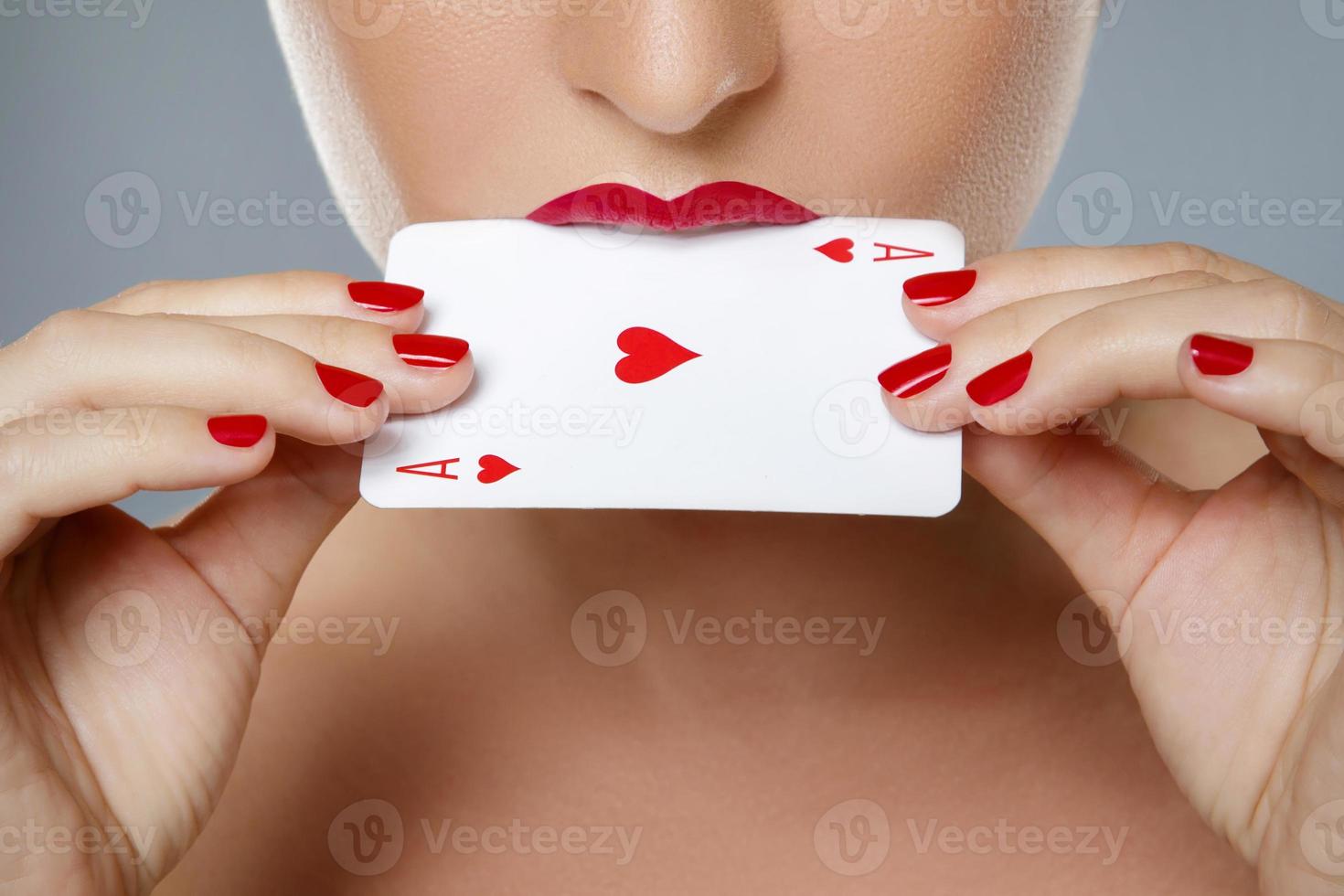 donna con rosso labbra è Tenere asso carta nel sua mani foto