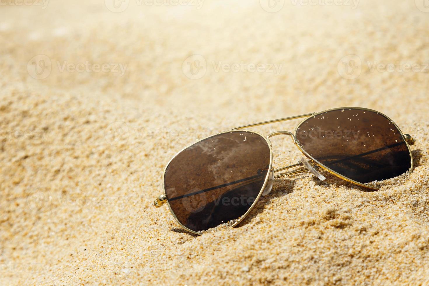 occhiali da sole sulla sabbia foto