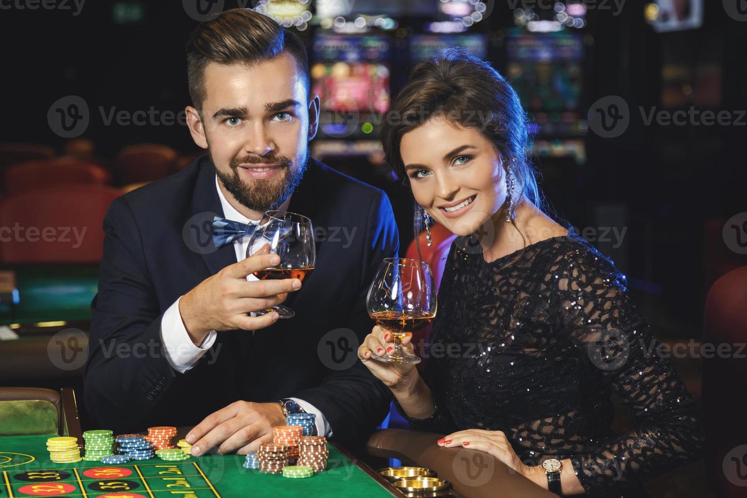 bellissimo e ricco coppia giocando roulette nel il casinò foto