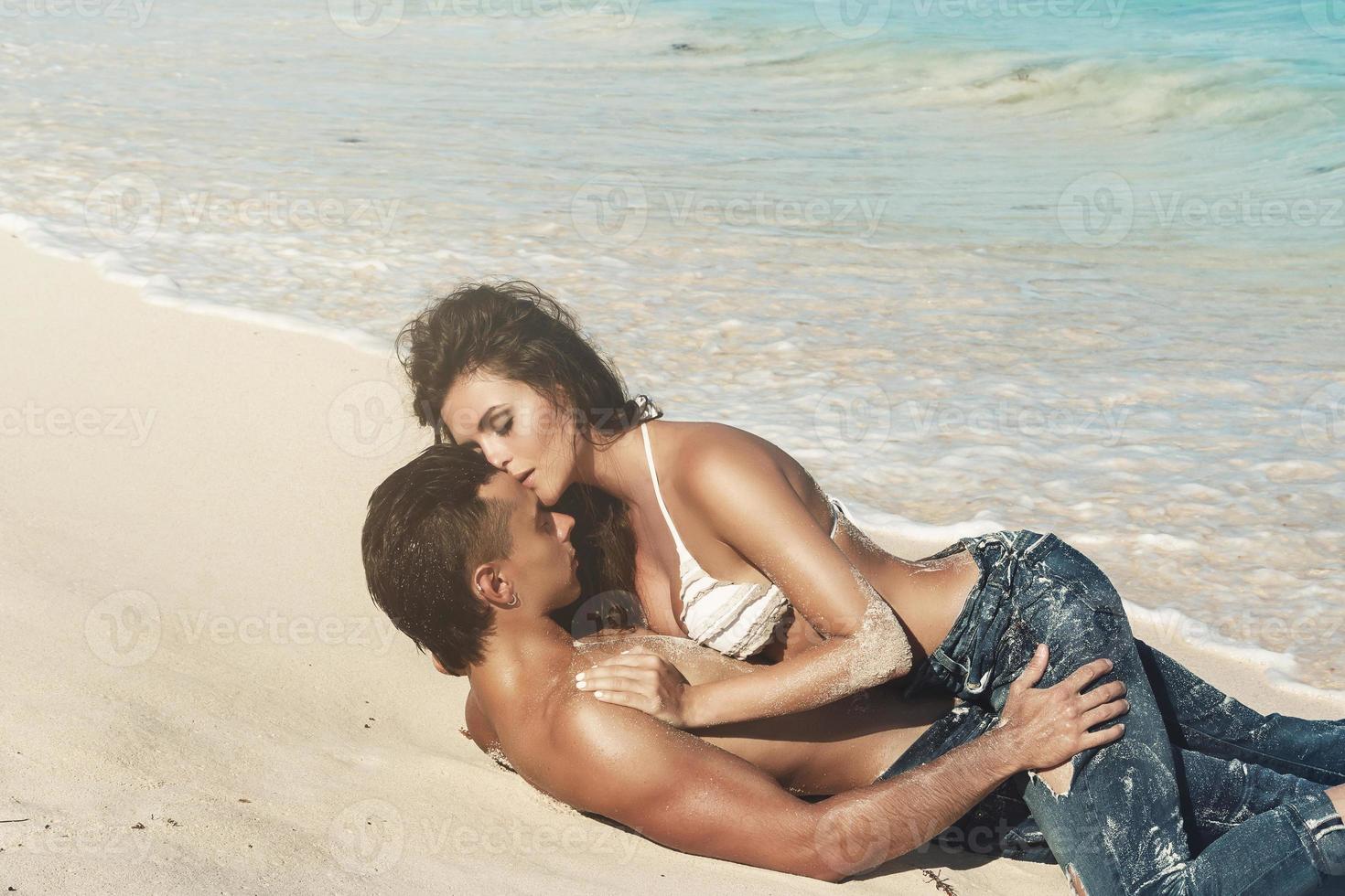bellissimo coppia indossare jeans su il tropicale spiaggia foto