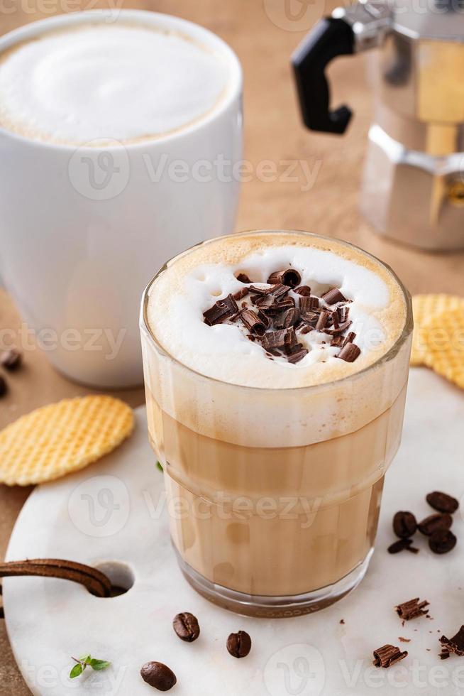 caldo caffè latte macchiato e cappuchino nel un' bicchiere e boccale foto