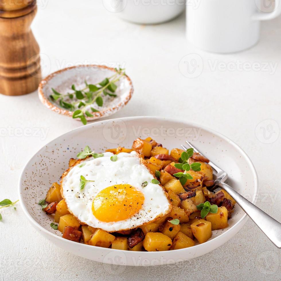 Patata, cipolla e prosciutto hash sormontato con fritte uovo foto
