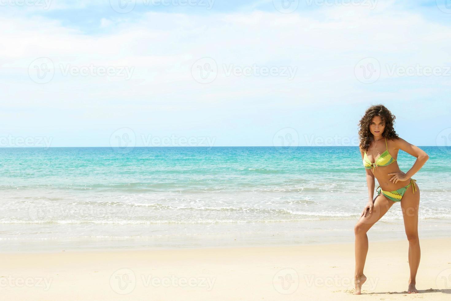 sexy donna con Riccio capelli su il spiaggia foto