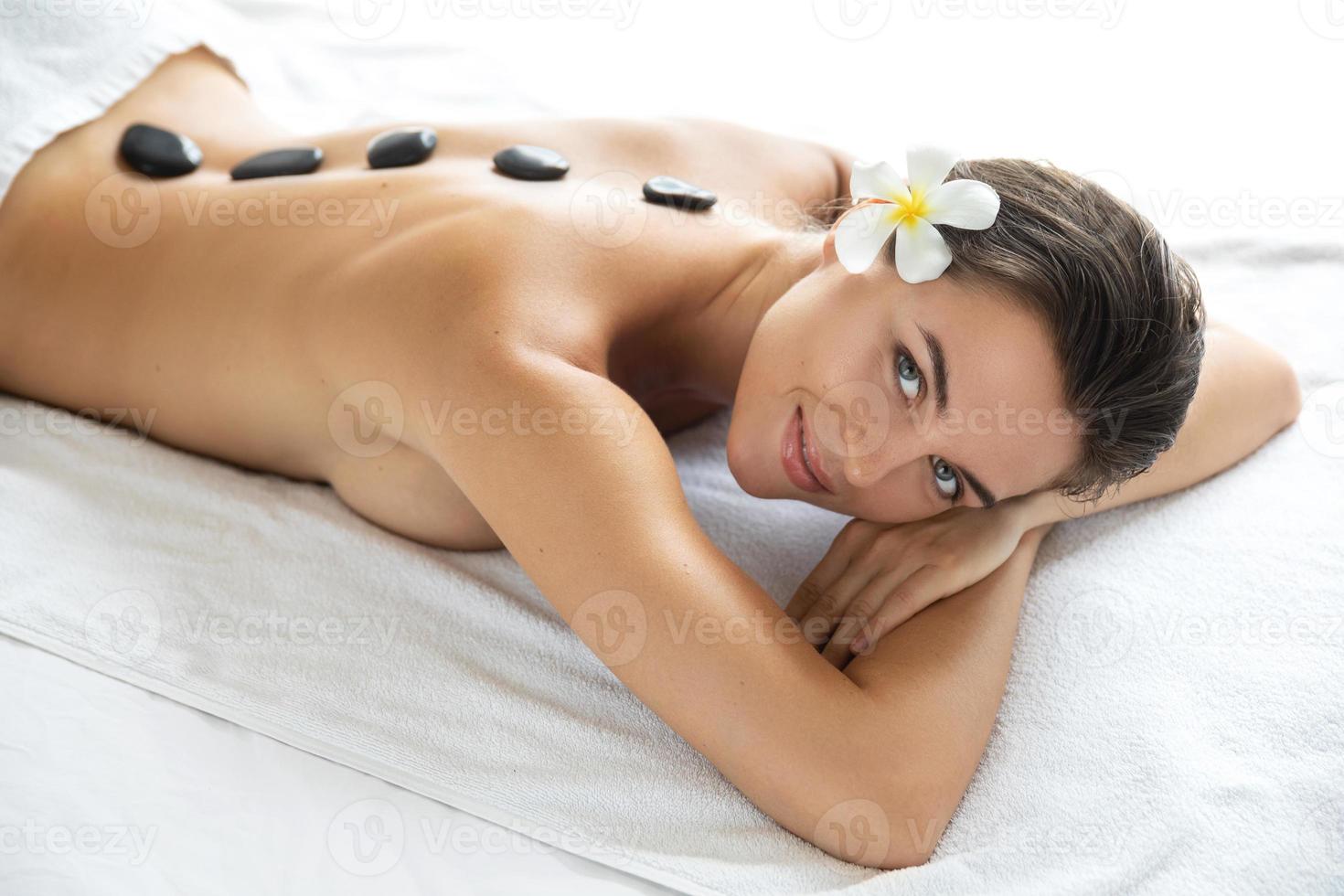giovane e bellissimo donna durante caldo pietre massaggio foto