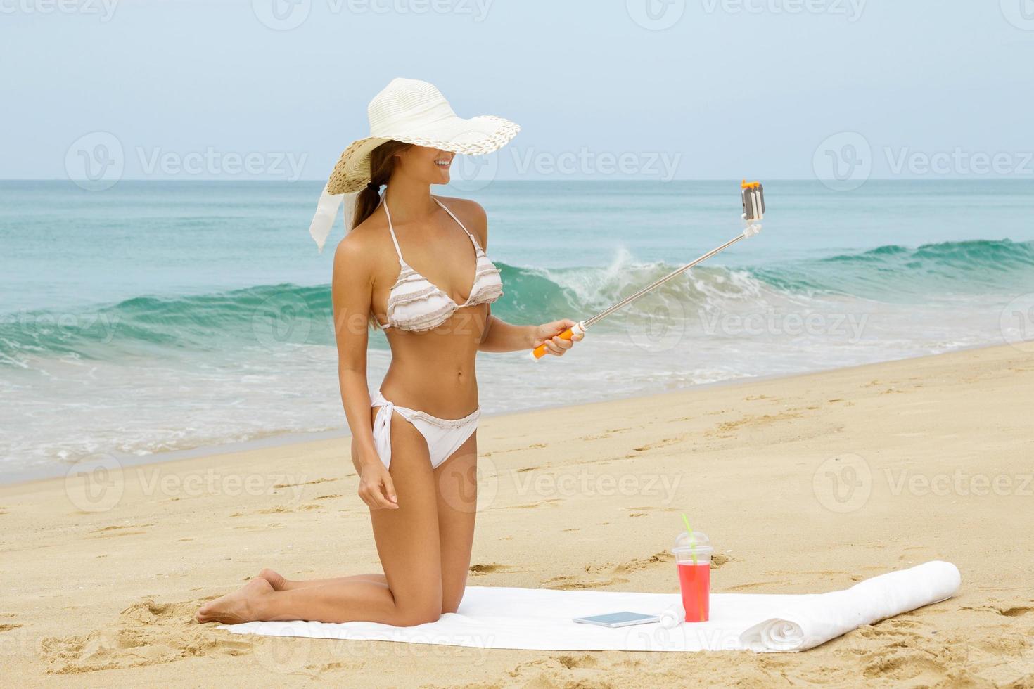 bellissimo donna è assunzione autoscatto su il spiaggia foto