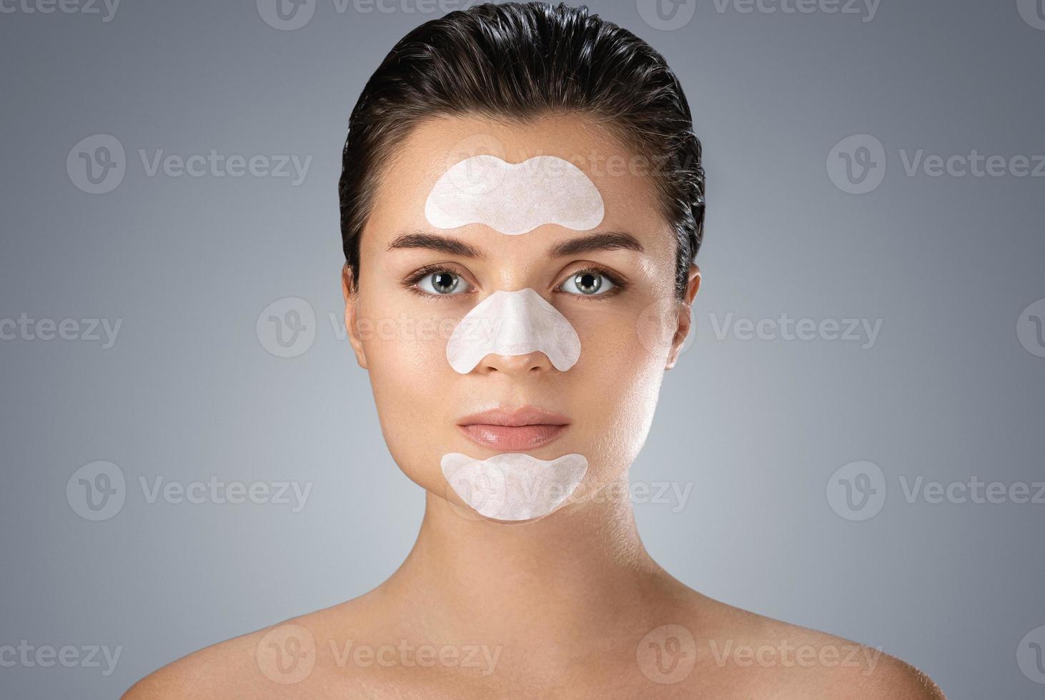 bellissimo donna con un' detergente poro strisce su sua viso foto