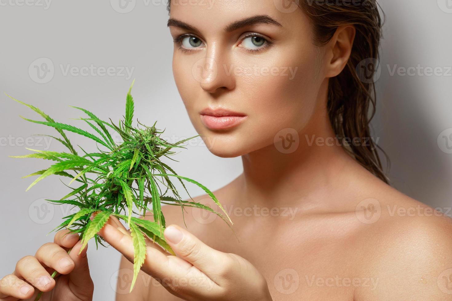 CBD cosmetici concetto. bellissimo donna con un' canapa foglia foto