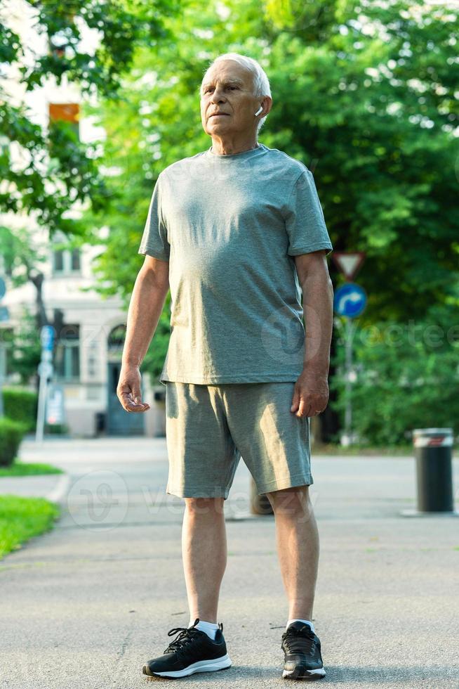 anziano uomo durante il suo jogging allenarsi nel un' città parco foto