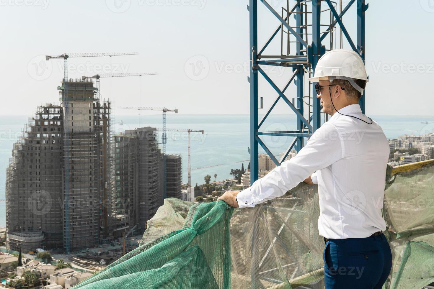 fiducioso architetto o uomo d'affari indossare difficile cappello guardare su un' costruzione luogo foto