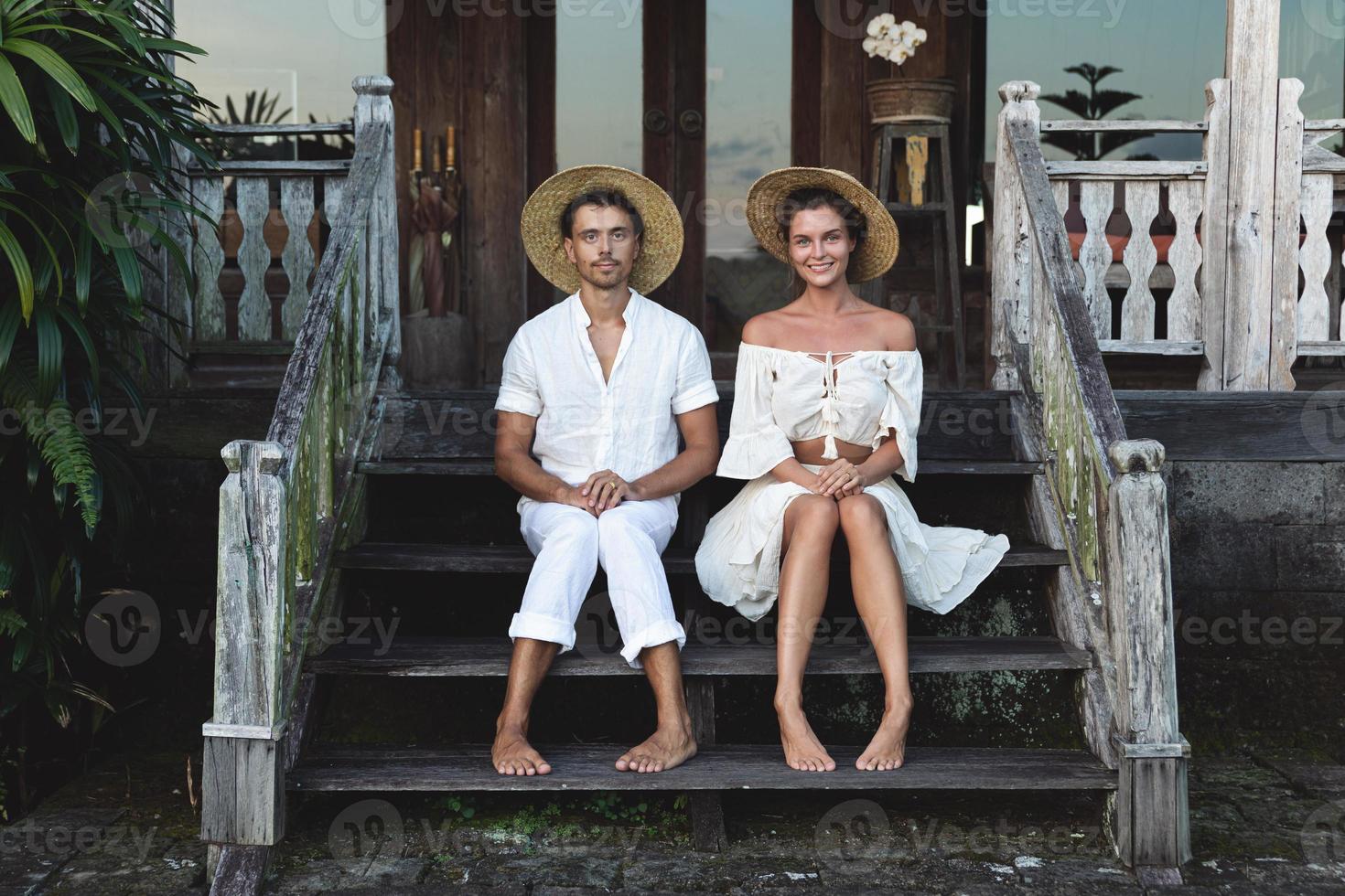 giovane bello coppia seduta su il le scale di il veranda foto