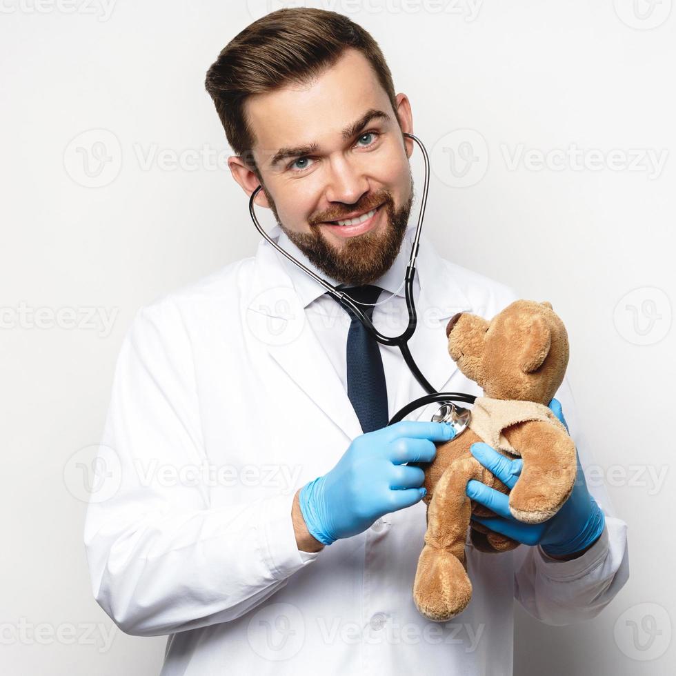 professionale pediatra con un' orsacchiotto orso nel il suo mani foto