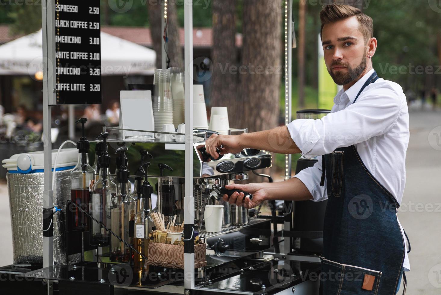 bello barista uomo durante opera nel il suo strada caffè negozio foto