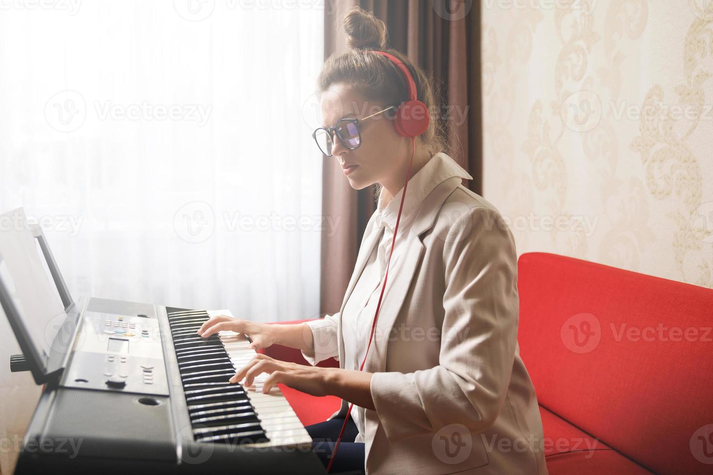 giovane donna musicista giocando sintetizzatore a casa foto