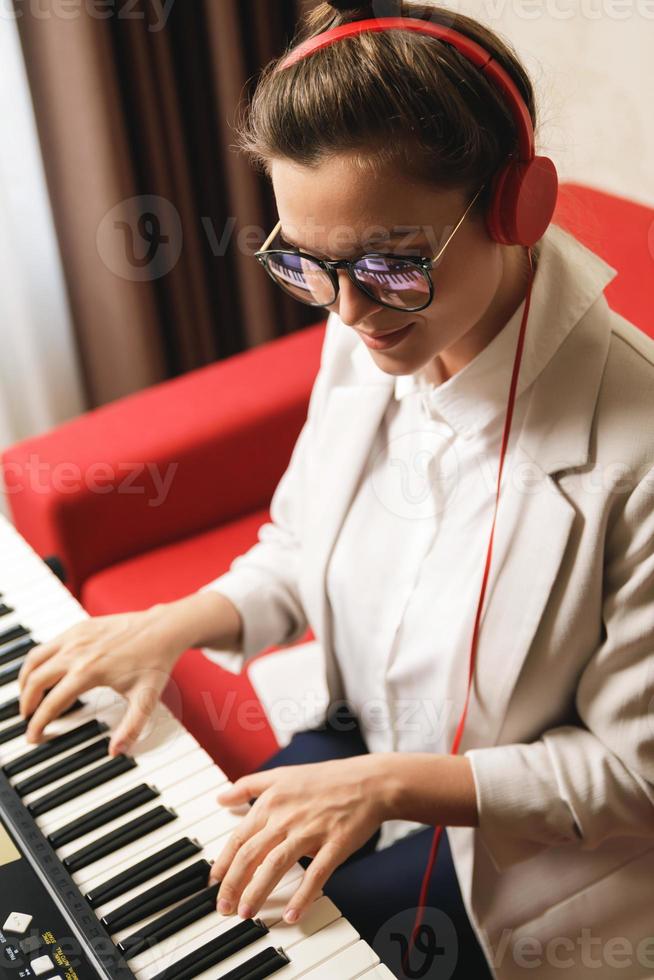 giovane donna musicista giocando sintetizzatore a casa foto