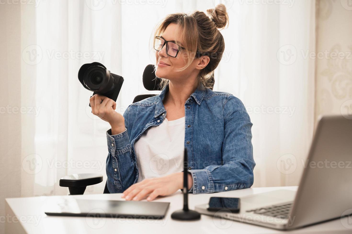 contento donna fotografo con un' mirrorless telecamera a il posto di lavoro foto