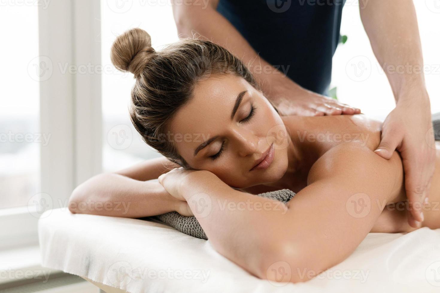 massaggiatore uomo fare indietro massaggio per il suo cliente foto