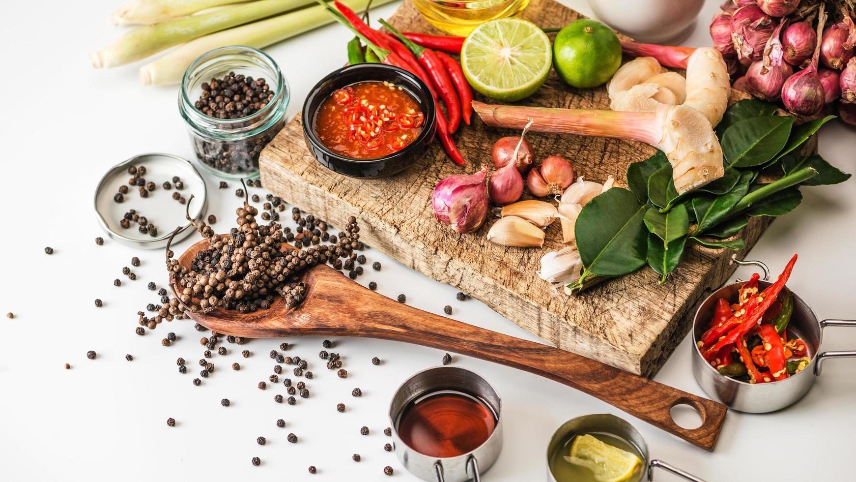 spezie da utilizzare come ingredienti da cucina su uno sfondo di legno con verdure fresche. erbe alimentari sane. verdure biologiche sul tavolo. materie prime di cottura preparazione tom yum. foto