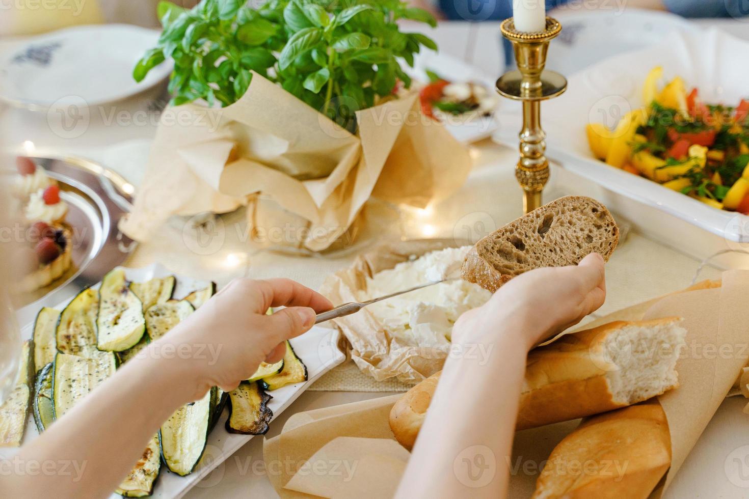 donna fabbricazione un' Sandwich a il festivo tavolo. foto