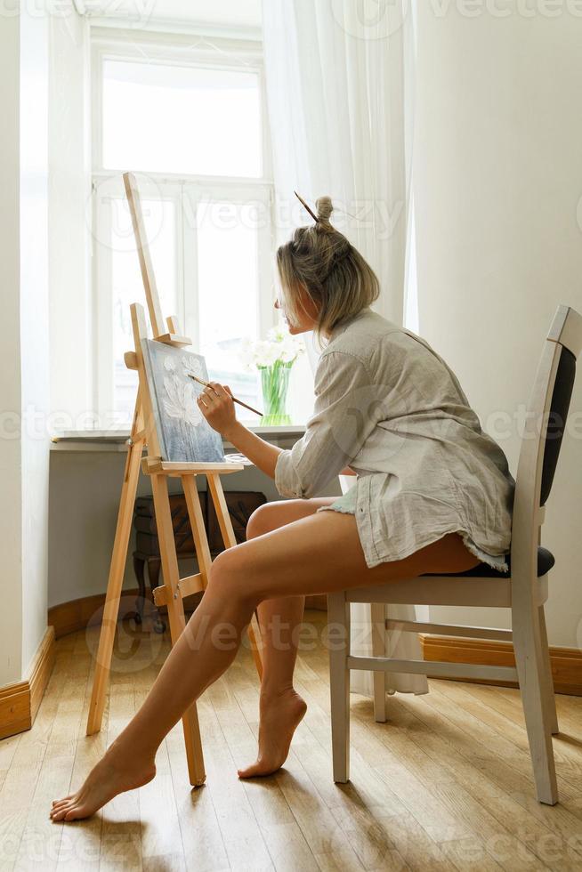 giovane donna artista pittura su tela su il cavalletto foto