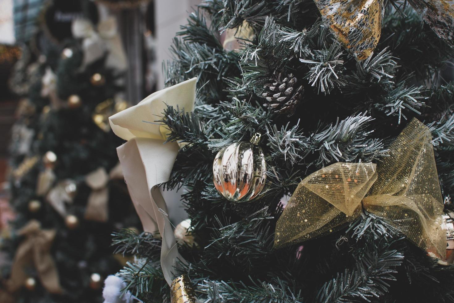 un' avvicinamento di d'oro Natale ornamenti e pino coni sospeso su un' albero foto