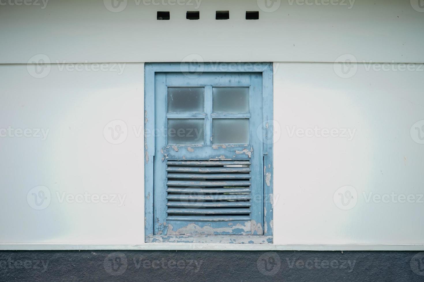 Vintage ▾ di legno finestra con blu dipingere su bianca parete foto