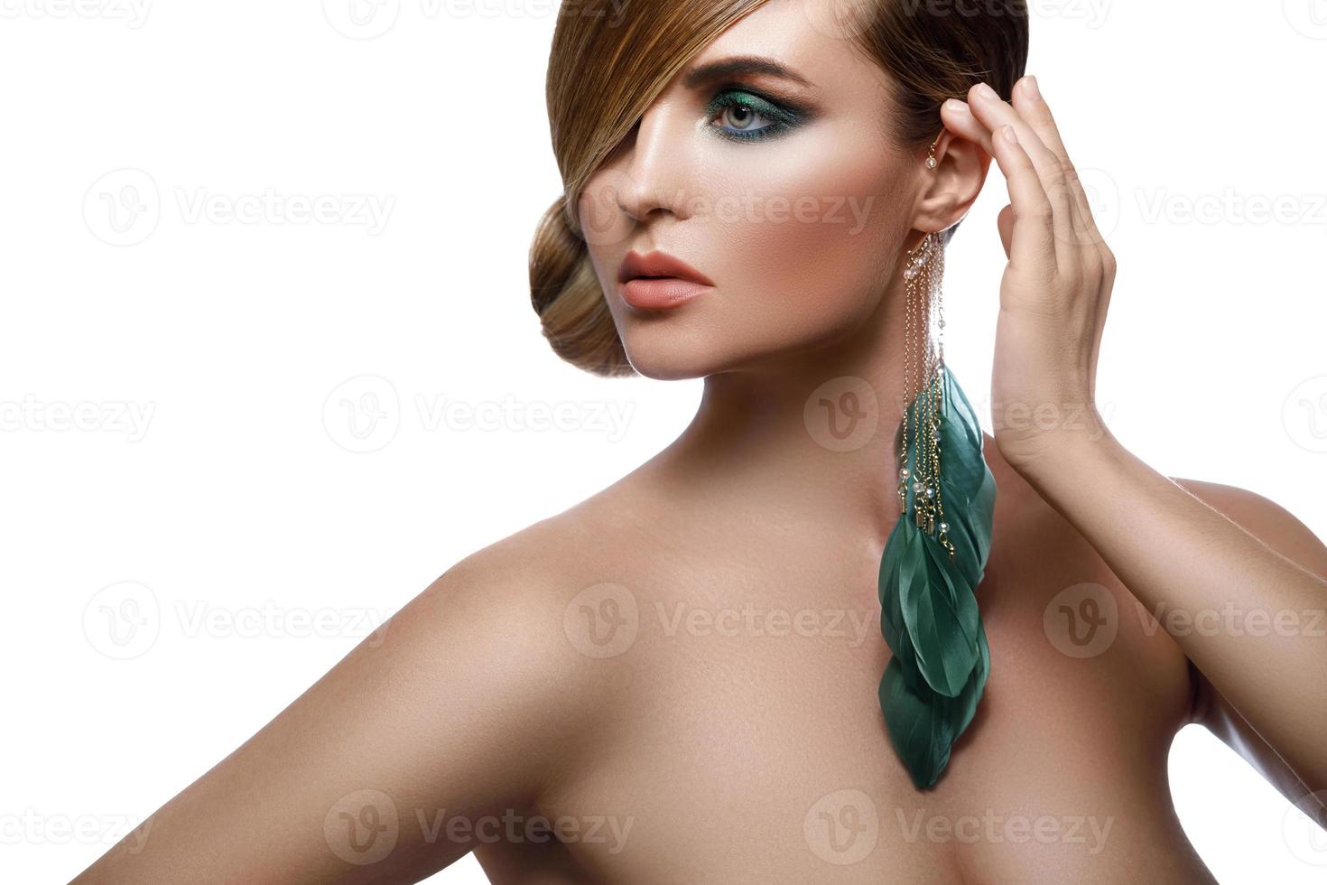 modello nel elegante Immagine con elegante capelli copertura uno occhio e piuma orecchino foto