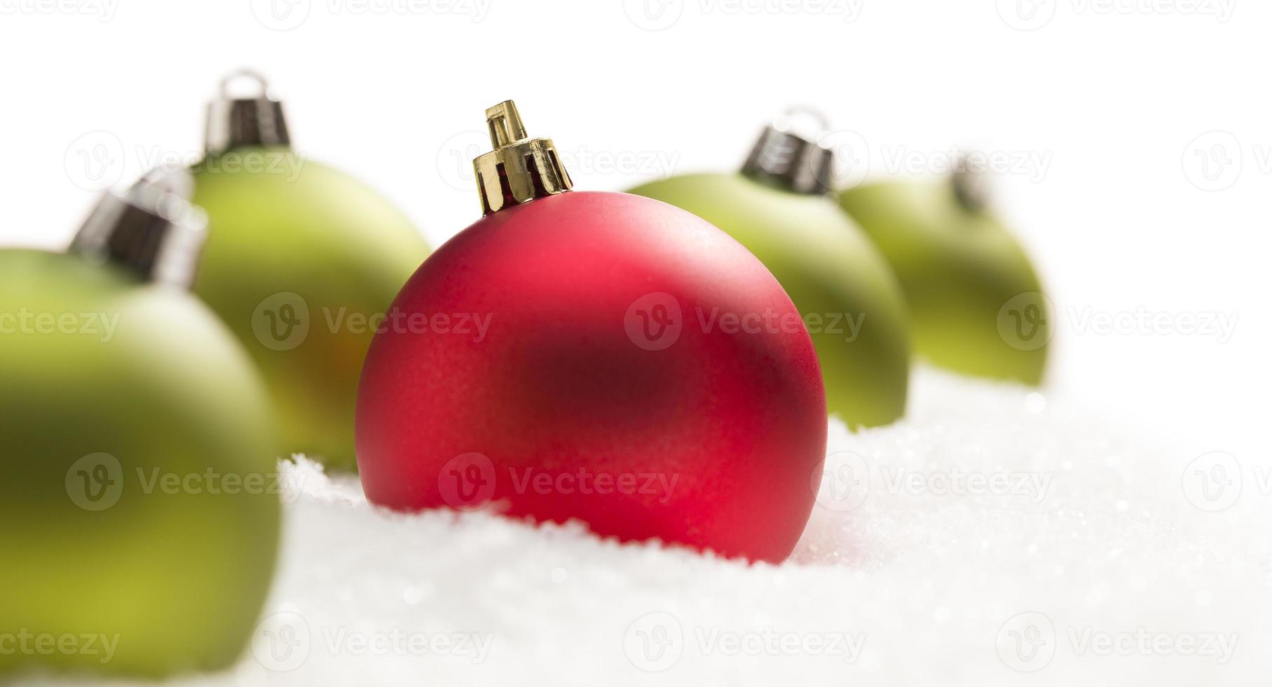 rosso e verde Natale ornamenti su neve fiocchi su bianca foto