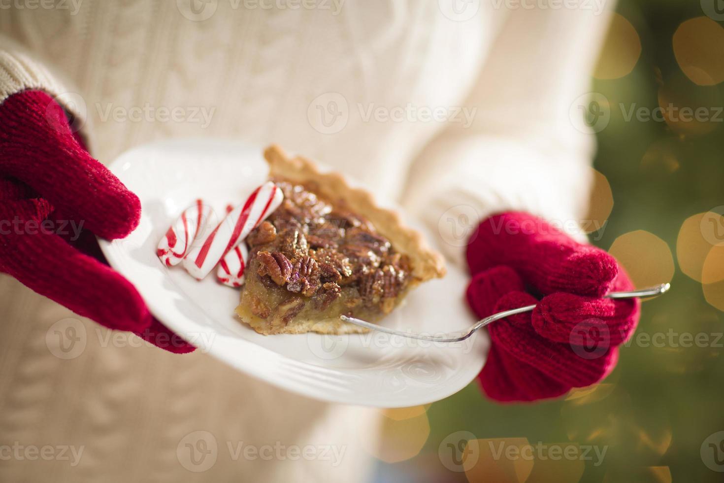 donna indossare rosso guanti Tenere piatto di pecan torta, menta piperita foto