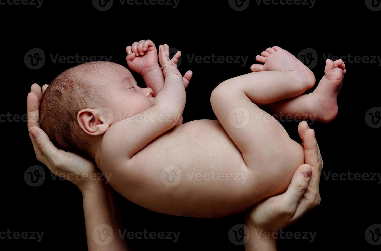 carino neonato bambino dire bugie nel il La madre di mani foto