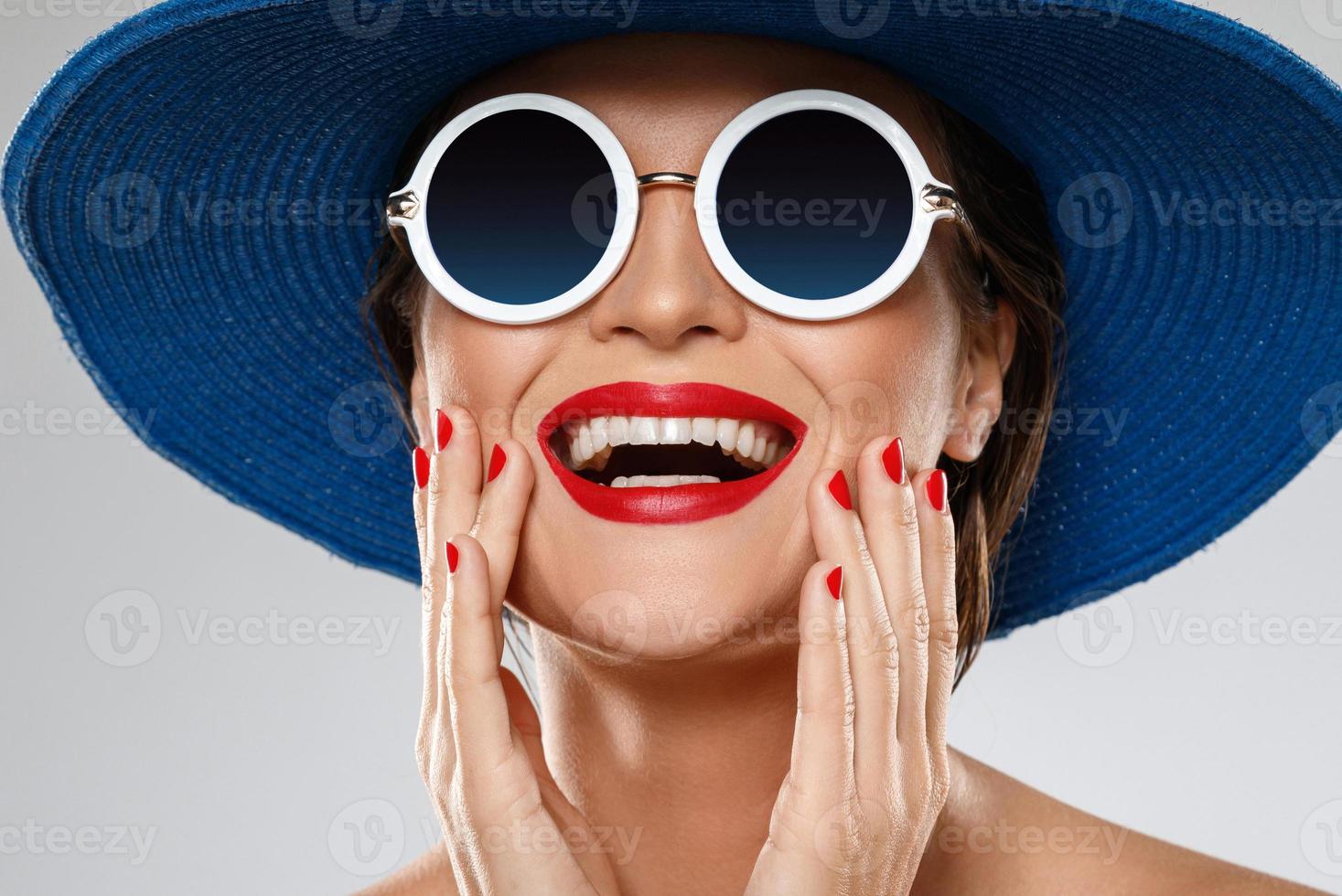 bellissimo donna indossare blu cappello e occhiali da sole è pronto per vacanza foto