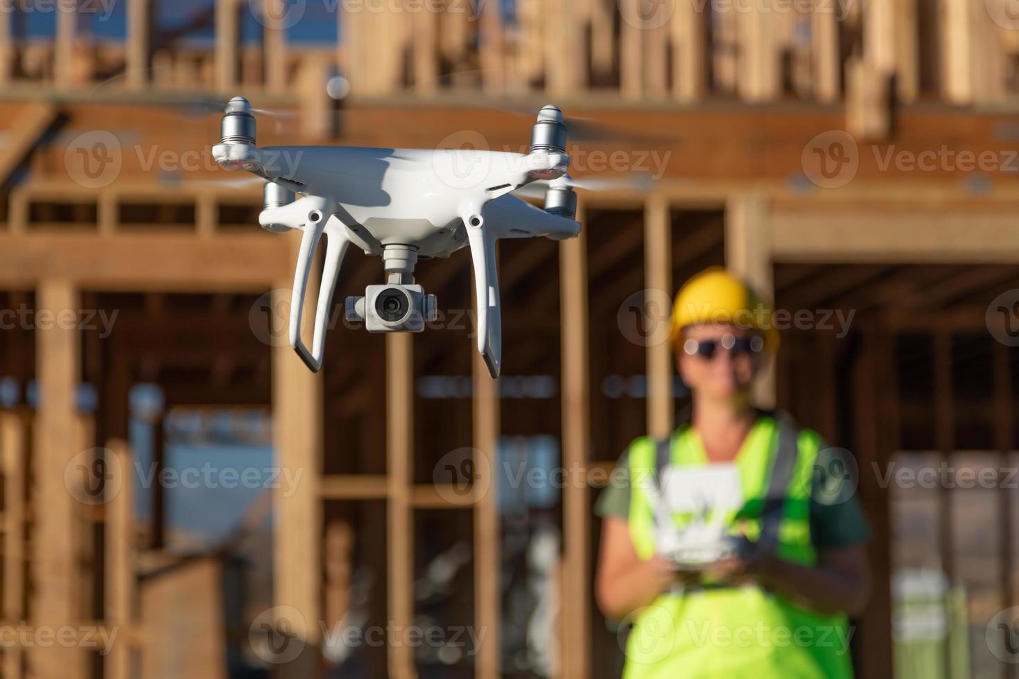 femmina pilota mosche fuco quadcopter ispezionando costruzione luogo foto