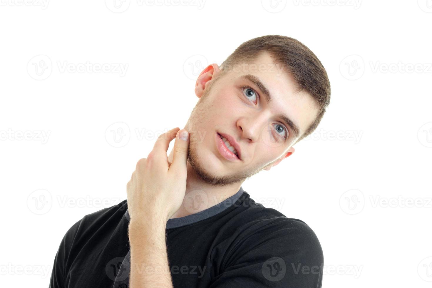 bello giovane tipo con un' barba inclinata il suo testa e mantiene un' mano vicino il collo è isolato su un' bianca sfondo foto