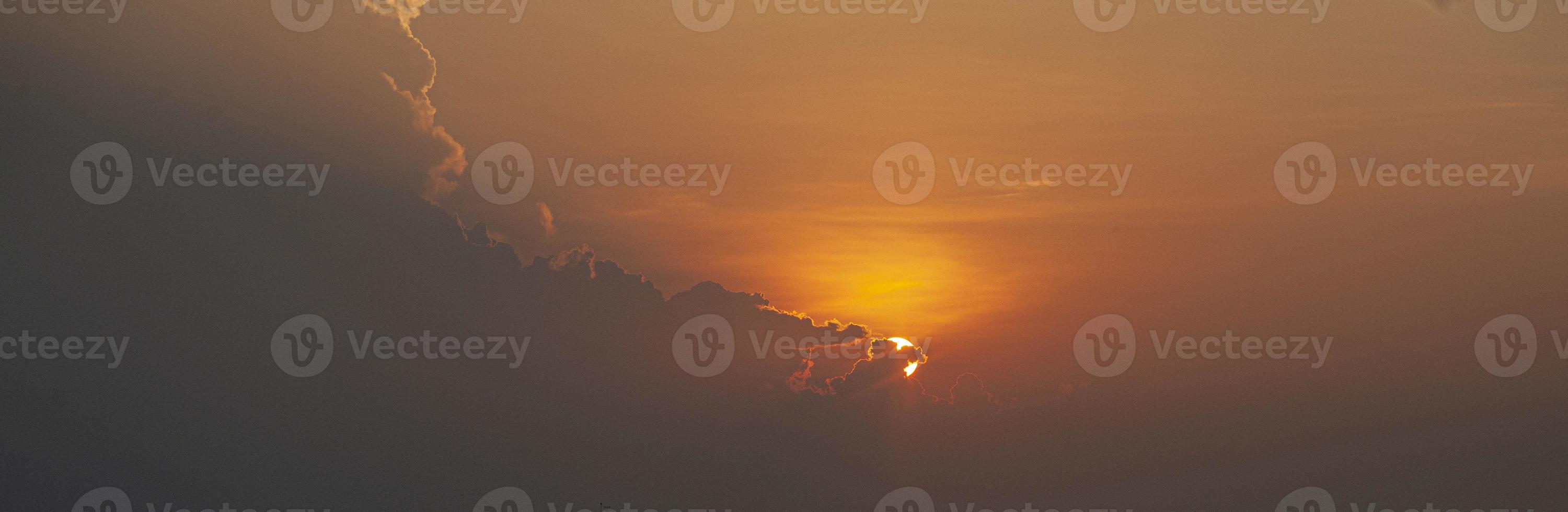 immagine di drammatico e colorato cielo con sole durante tramonto foto