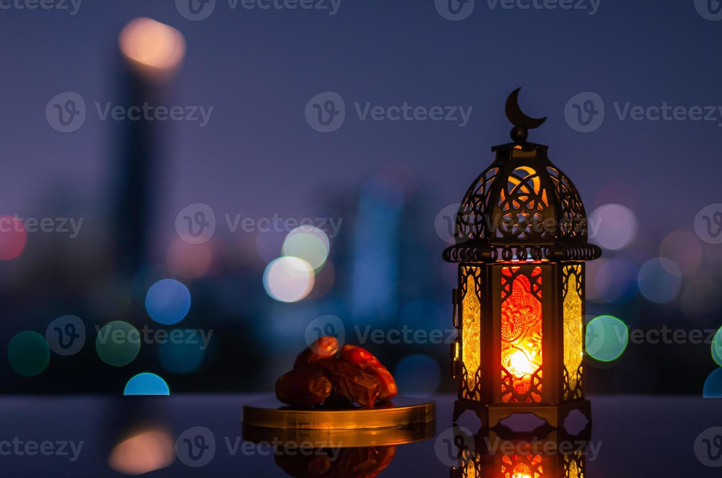 lanterna quello avere Luna simbolo su superiore e piccolo piatto di date frutta con notte cielo e città bokeh leggero sfondo per il musulmano festa di il santo mese di Ramadan kareem. foto