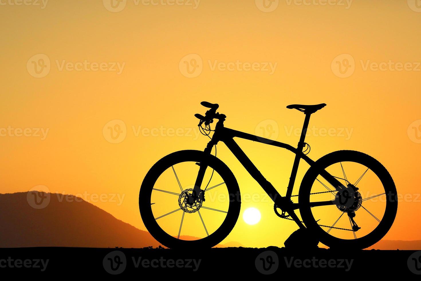 silhouette di un' bicicletta su tramonto foto