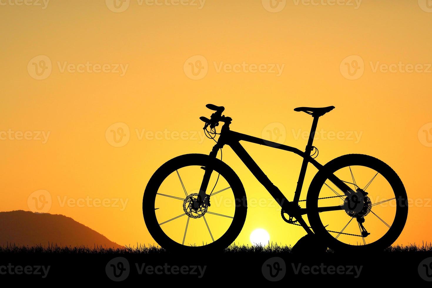 silhouette di un' bicicletta su tramonto foto
