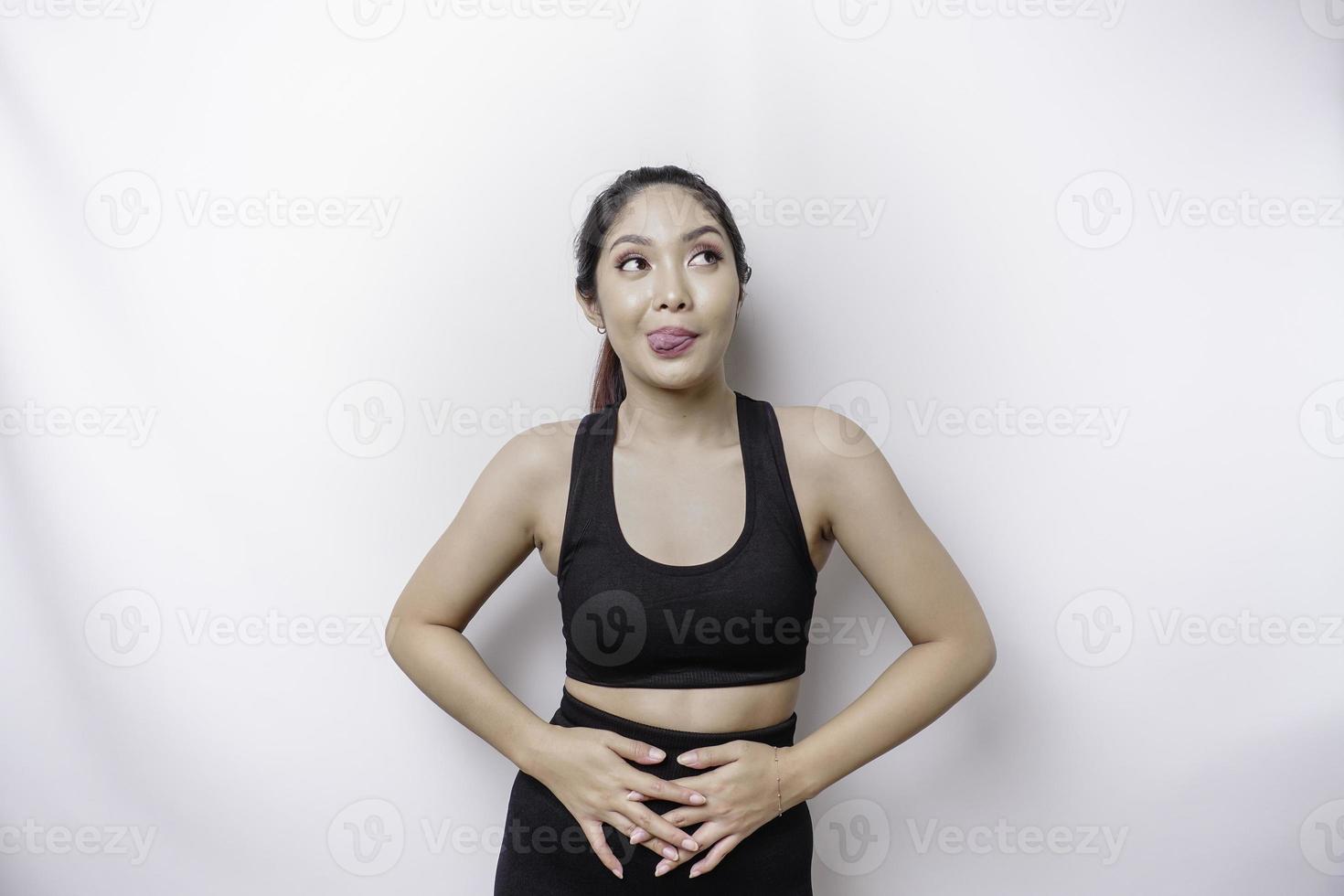 un' sportivo asiatico donna è Affamato e toccante sua pancia mentre guardare a parte pensiero che cosa per mangiare foto