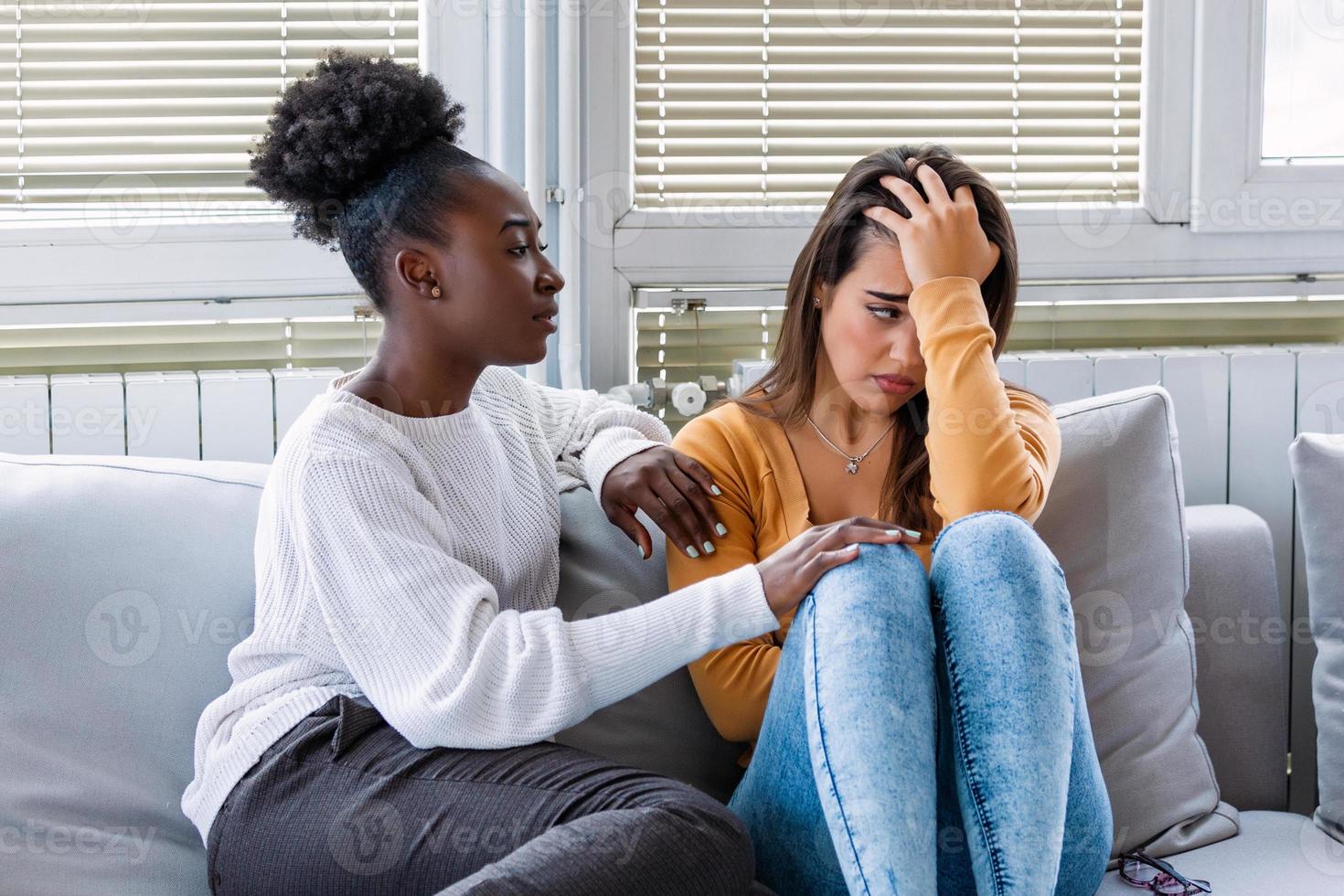 donna abbracciare sua depresso amico a casa, avvicinamento. giovane ragazza supporto sua pianto fidanzata. amicizia consolante e cura, copia spazio foto