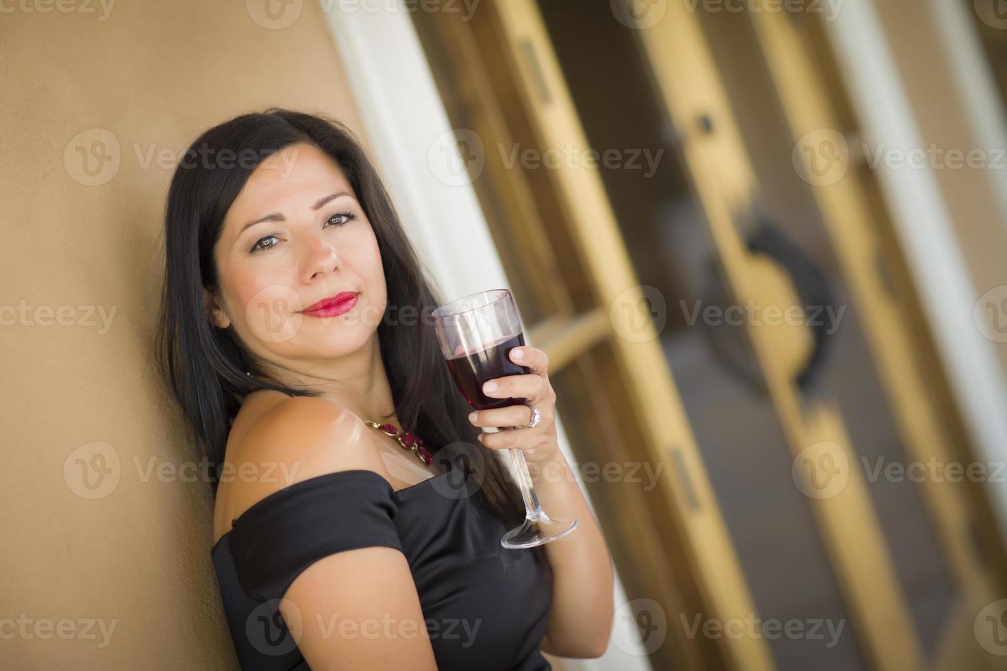 attraente ispanico donna ritratto al di fuori godendo vino foto
