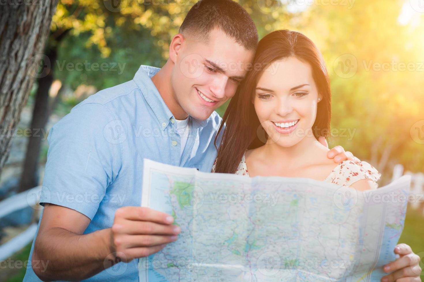 contento misto gara coppia guardare al di sopra di un' carta geografica al di fuori insieme. foto