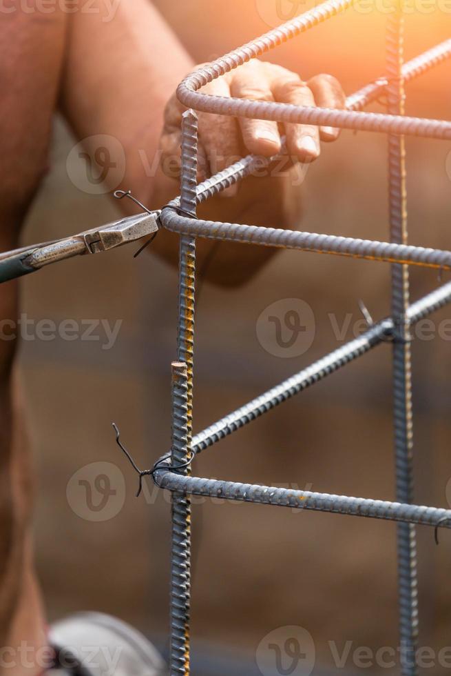 lavoratore fissaggio acciaio tondo per cemento armato inquadratura con filo pinza fresa attrezzo a costruzione luogo foto