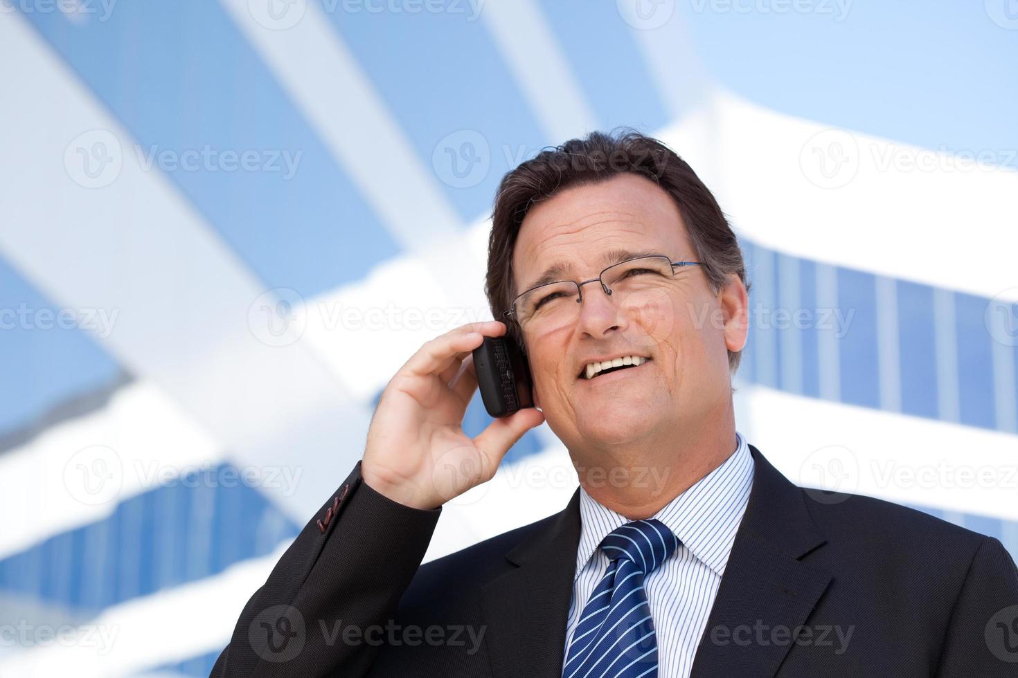 uomo d'affari sorrisi come lui parla su il suo cellula Telefono foto