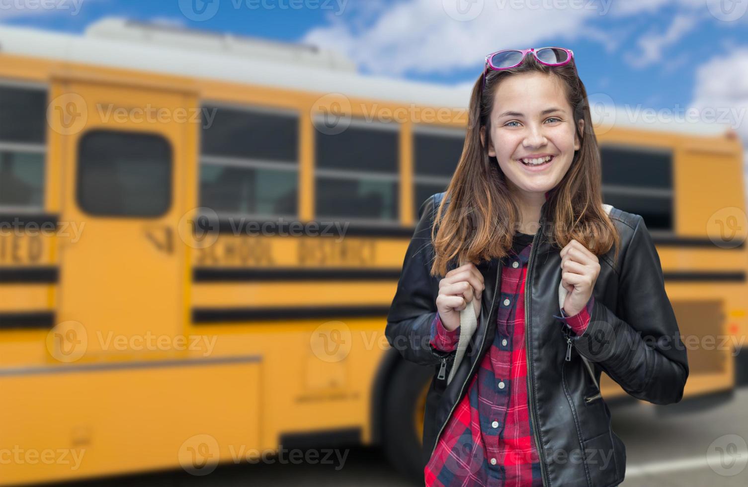 giovane femmina alunno vicino scuola autobus foto