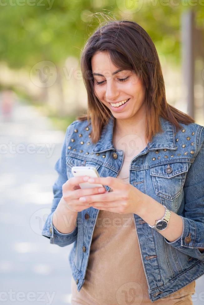 bellissimo giovane etnico donna utilizzando sua smartphone fuori. foto