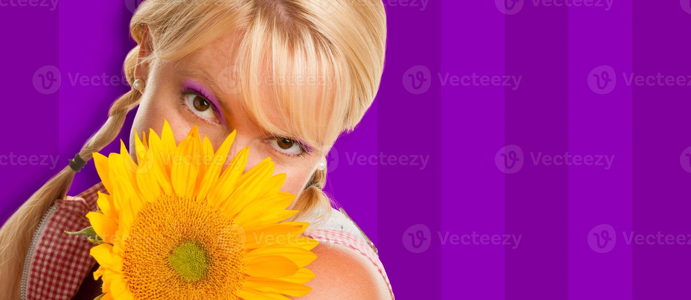 bellissimo ragazza Tenere giallo girasole contro viola a strisce sfondo foto