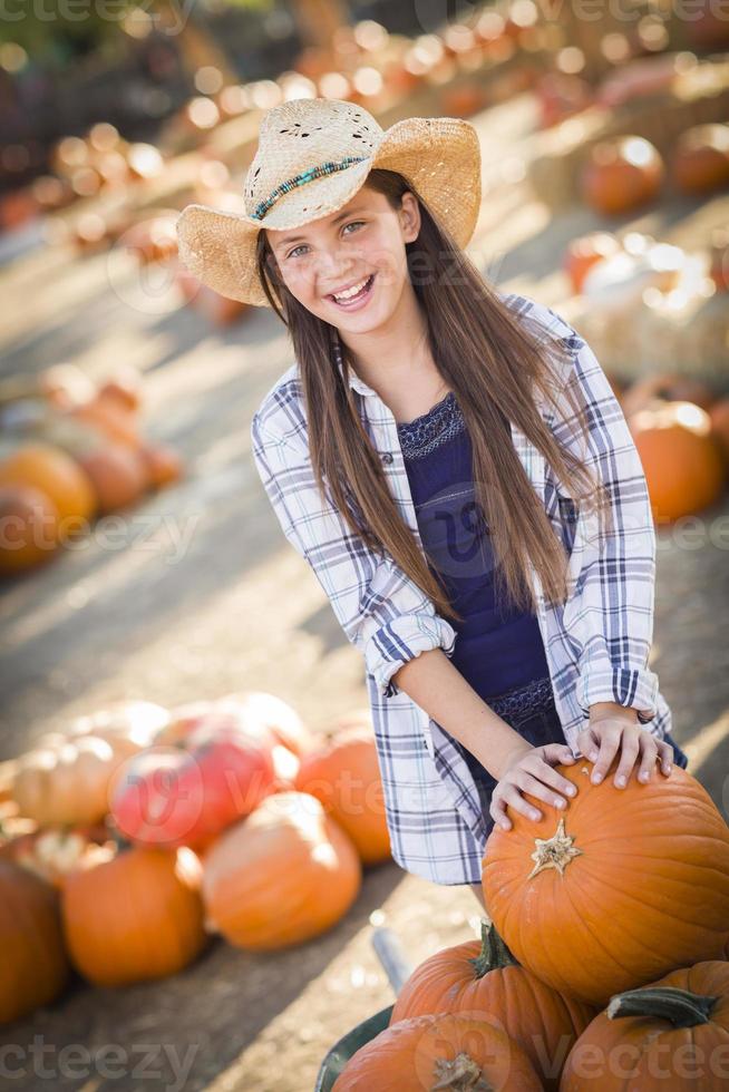 preteen ragazza giocando con un' carriola a il zucca toppa foto