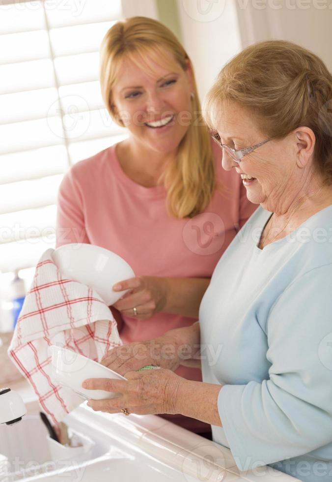 anziano adulto donna e giovane figlia parlando nel cucina foto