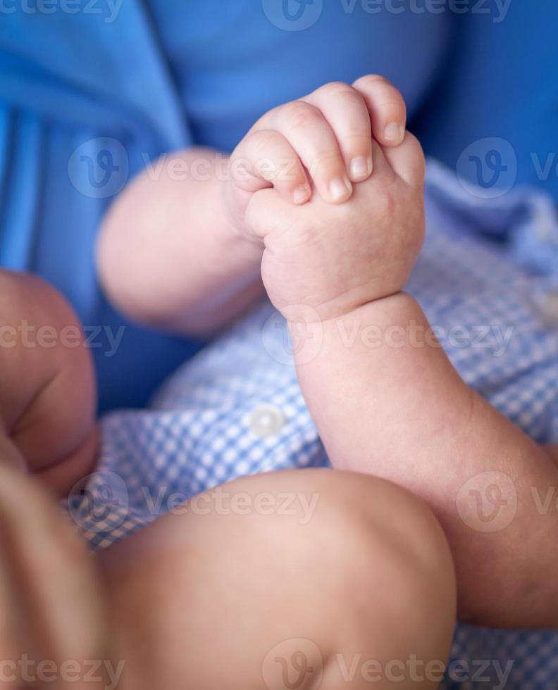 avvicinamento di infantile mani mentre posa su giro di madre foto