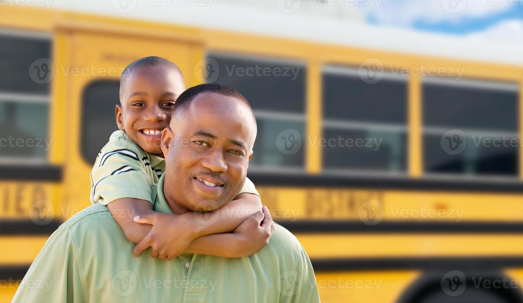 africano americano uomo e bambino a cavalluccio vicino scuola autobus foto